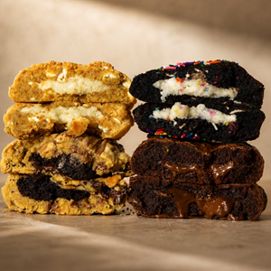 The image showcases a visually appealing arrangement of four decadent cookies, halved and stacked to reveal their rich fillings. The cookies are presented in two vertical stacks, side-by-side, against a muted, neutral background with a subtle texture, possibly parchment paper or a lightly textured wall. The lighting is soft and directional, casting gentle shadows that add depth and dimension to the scene.