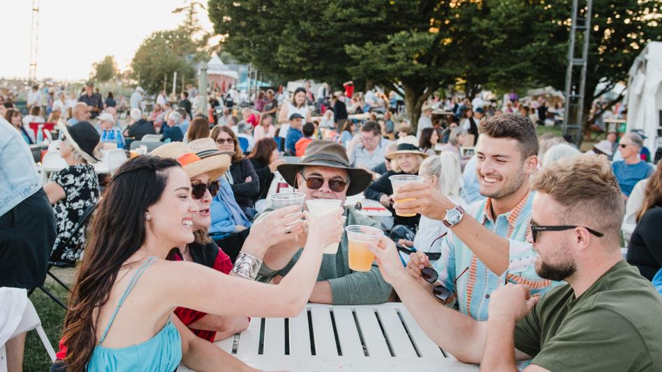 A lively concert crowd enjoying the music, with family and friends raising their glasses for a toast at the Park Royal Beachside Patio.
