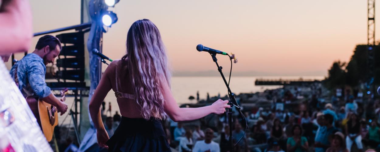  A diverse group of musicians performing together on stage at a lively concert, engaging the audience with their music.