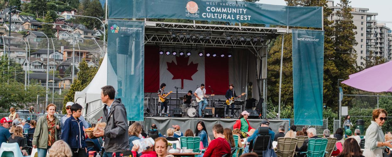 A band performs energetically on stage, with a prominent Canadian flag displayed in the background.
