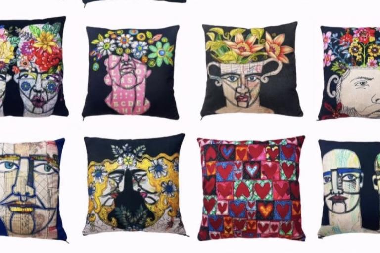 The image displays a grid of eight decorative pillows, arranged in two rows of four. All the pillows are square and feature distinct, artistic designs, primarily centered around stylized human faces and botanical elements, all set against dark backgrounds.