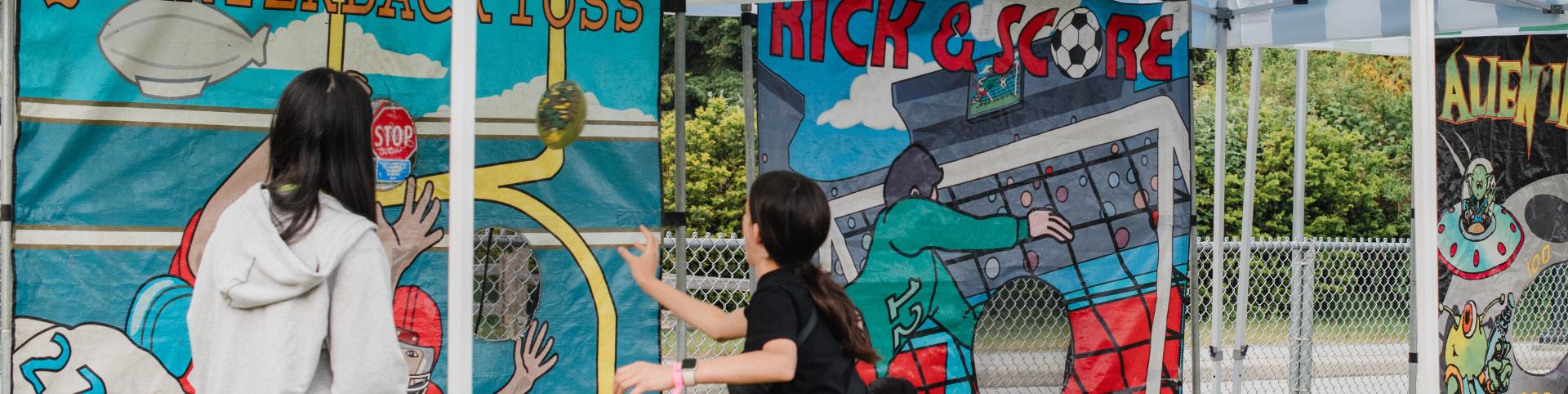 A person and a child are playing together in a play area, enjoying outdoor activities. The scene captures the joy of their interaction. The tags associated with this image include clothing, art, painting, and street-related elements.