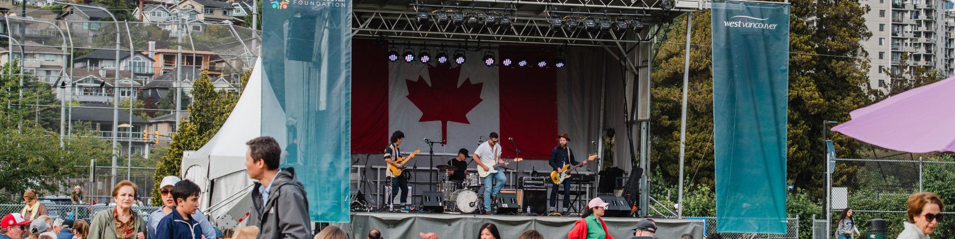 A band performs energetically on stage, with a prominent Canadian flag displayed in the background.